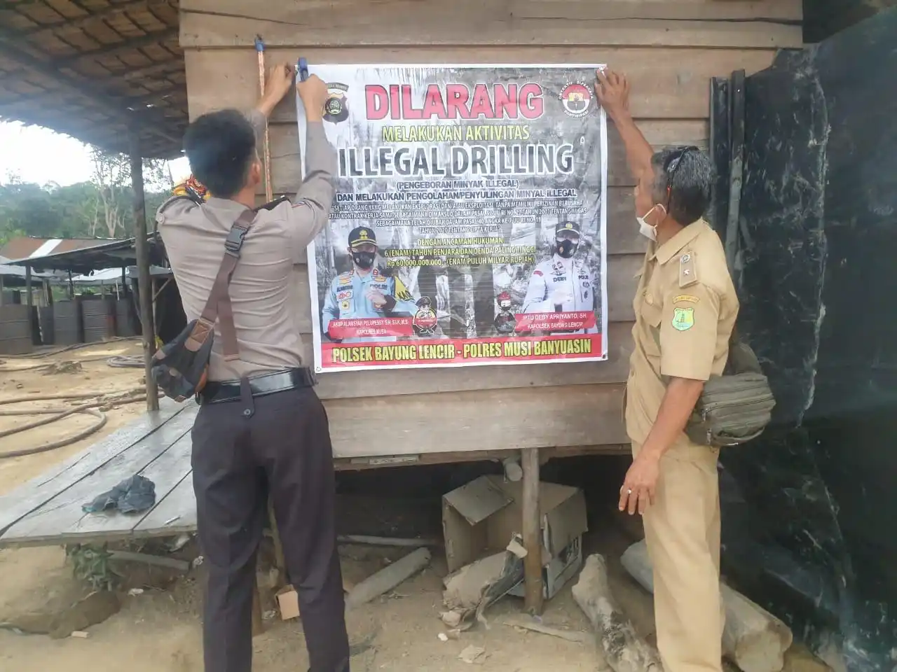 Anggota Polsek Bayung Lencir bersama perangkat desa memasang spanduk larangan aktivitas illegal drilling di Desa Sukajaya, Kecamatan Bayung Lencir, Kabupaten Muba, Jumat (22/8). (Foto: Dok/MI)