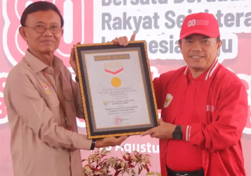 Gubernur Jambi, H Al Haris (kanan) menerima piagam Rekor MURI Pengibaran 1.000 bendera Merah Putih di Jembatan Gentala Arasy dari Direktur Operasional MURI, Yusuf Ngadri (kiri) di Kota Jambi, Provinsi Jambi, Sabtu (16/8/2025). (Foto : Ist).