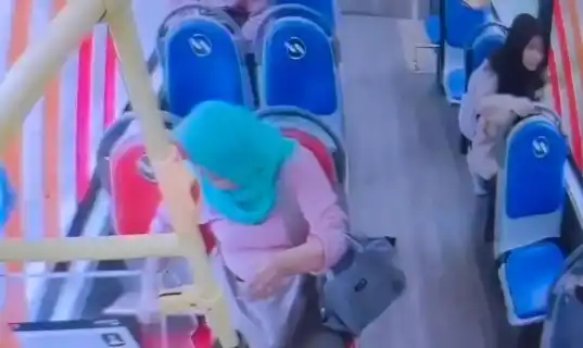 Rekaman CCTV yang memperlihatkan pelaku pencurian berinisial M (memakai penutup kepala berwarna hijau) saat mencuri laptop yang tertinggal di Bus Transjakarta, Jakarta, Kamis (15/5/2025). [Foto: Polres Metro Jakarta Selatan]