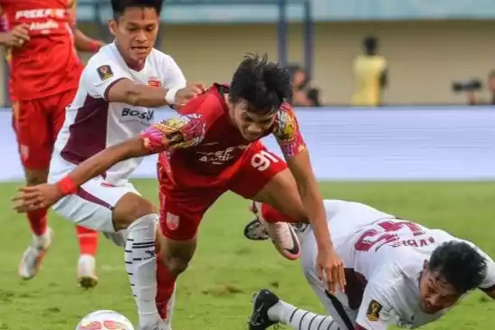 Pesepak bola Persis Solo Rendy Sanjaya berebut bola dengan PSM Makassar