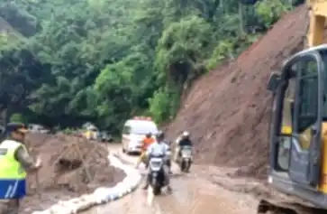 Pengendara motor dan mobil hendak melintasi jalur longsor (Foto: Screenshot)