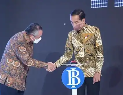 Joko Widodo berjabat tangan dengan Gubernur Bank Indonesia Perry Warjiyo saat Peluncuran Kartu Kredit Pemerintah Domestik dan QRIS Antarnegara di Gedung Thamrin, Bank Indonesia, Jakarta, Senin, 29 Agustus 2022 (Foto: Dok MI/An)