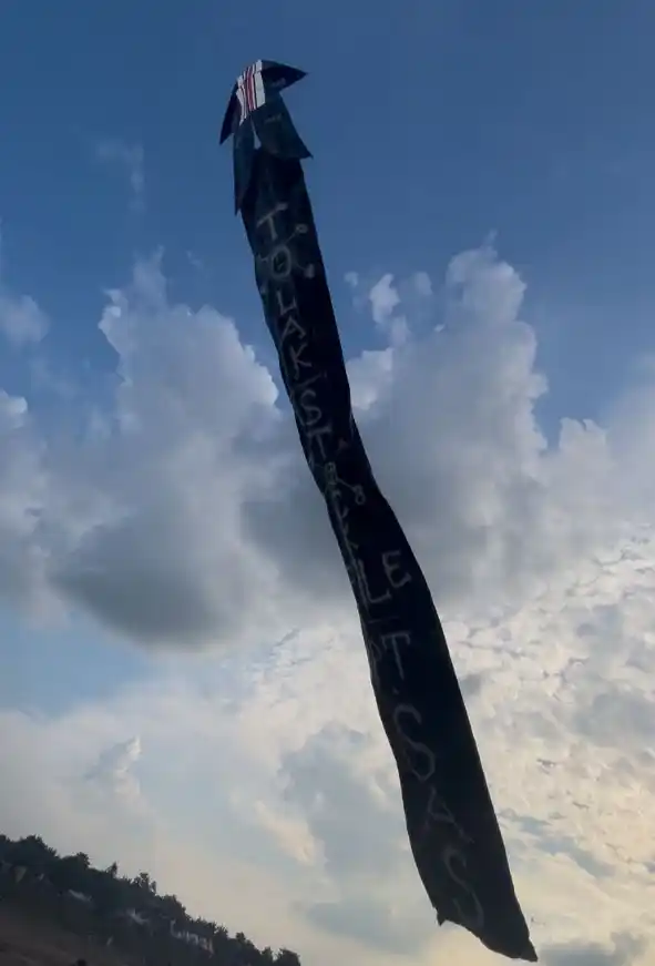 Layang-layang hitam berukuran raksasa dengan pesan “Tolak Stockpile PT. SAS” terbang tinggi di langit Festival Layang-Layang Jambi, 14 Agustus 2025, sebagai simbol protes warga terhadap aktivitas perusahaan yang dinilai merusak lingkungan.