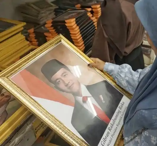 Warga sedang melihat untuk membeli foto Wakil Presiden Gibran Rakabuming Raka yang telah dibingkai dan dijual di Toko Agung, Kota Makassar, Sulawesi Selatan, Senin (21/10/2024).