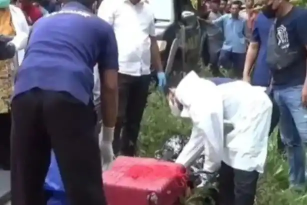 Petugas mengevakuasi jasad wanita dalam koper merah yang ditemukan di Desa Dadapan, Kecamatan Kendal, Kabupaten Ngawi pada Kamis (23/1/2025).