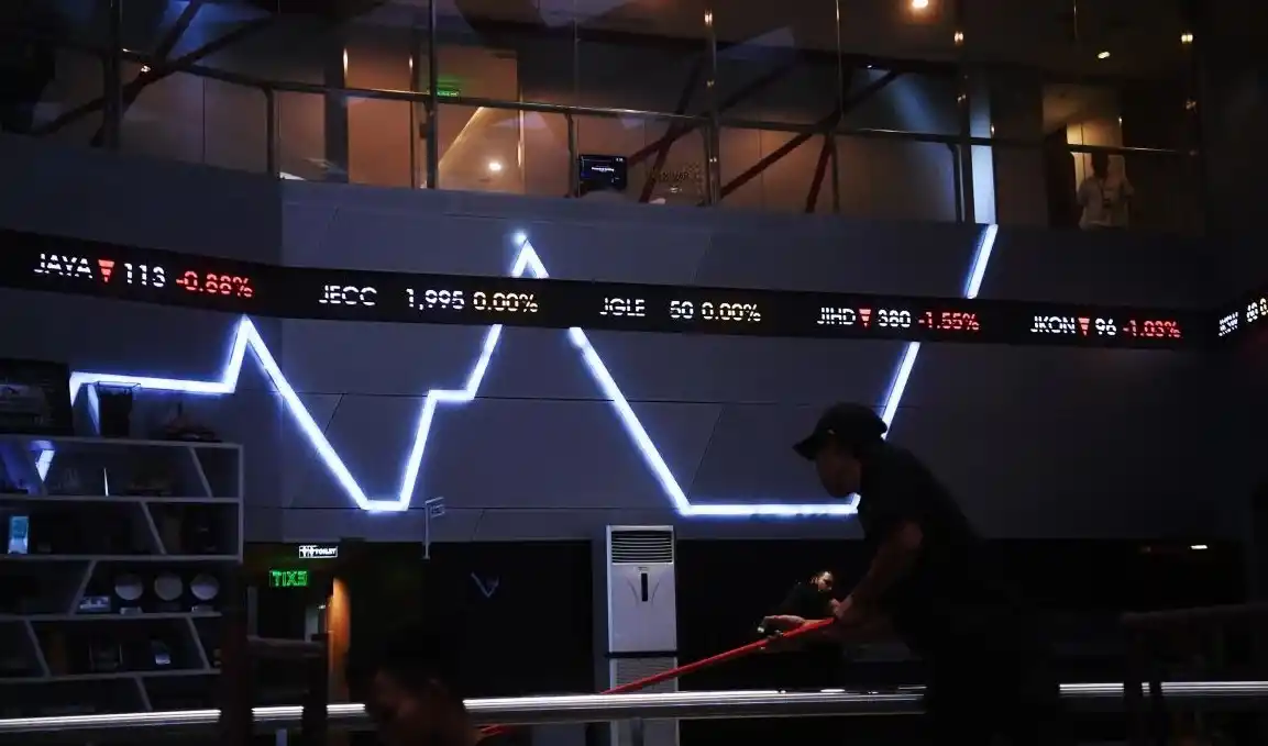Pekerja melintasi layar digital pergerakan saham di Bursa Efek Indonesia (Foto: Ist))