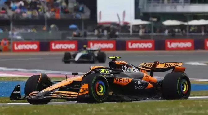 Pembalap McLaren Lando Norris dan pembalap Mercedes Lewis Hamilton (belakang) berlomba dalam GP Inggris di sirkuit Silverstone, Inggris, 7 Juli 2024. (ANTARA/AFP/BENJAMIN CREMEL)