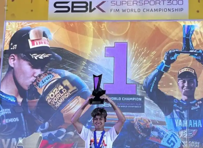 Pembalap motor Indonesia Aldi Satya Mahendra mengangkat trofi juara World Supersport300. (Foto: Antara)