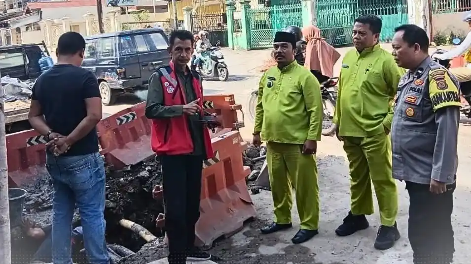 Bhabinkamtibmas Kelurahan Rajawali, Aipda Wawan Priawan, bersama Lurah Ari Dirgantara saat meninjau kondisi drainase tersumbat di Jalan Panglima Polim RT 17, Selasa (24/6/2025)