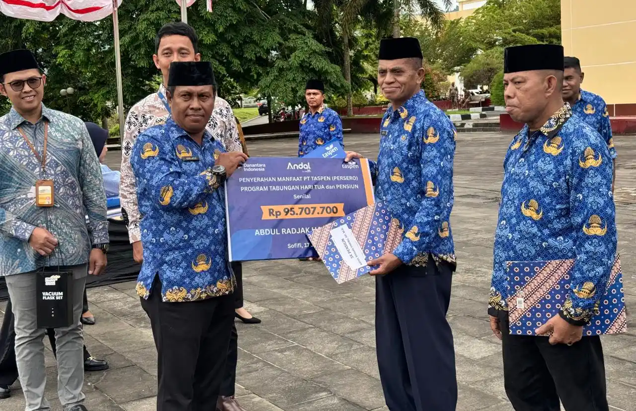 Asisten I Pemprov Malut, Kadri Laetje, menyerahkan manfaat Taspen senilai Rp95,7 juta kepada mantan Plt Kepala BPMD Malut, Abdul Radjak Habibu (Foto: Dok MI)