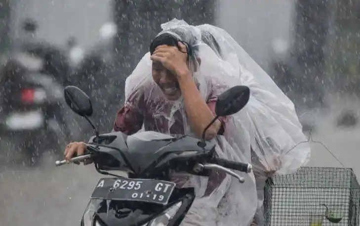 Pengendara motor mengenakan jas hujan (Foto: Antara)