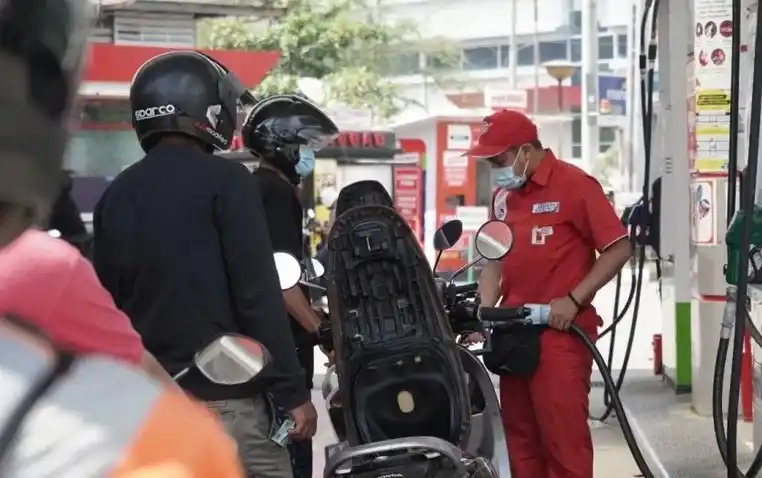 Petugas mengisi pertamax ke tangki motor pelanggan di Balikpapan. Harga pertamax yang kini jauh di atas pertalite menyebabkan konsumen pertamax berpindah ke pertalite.