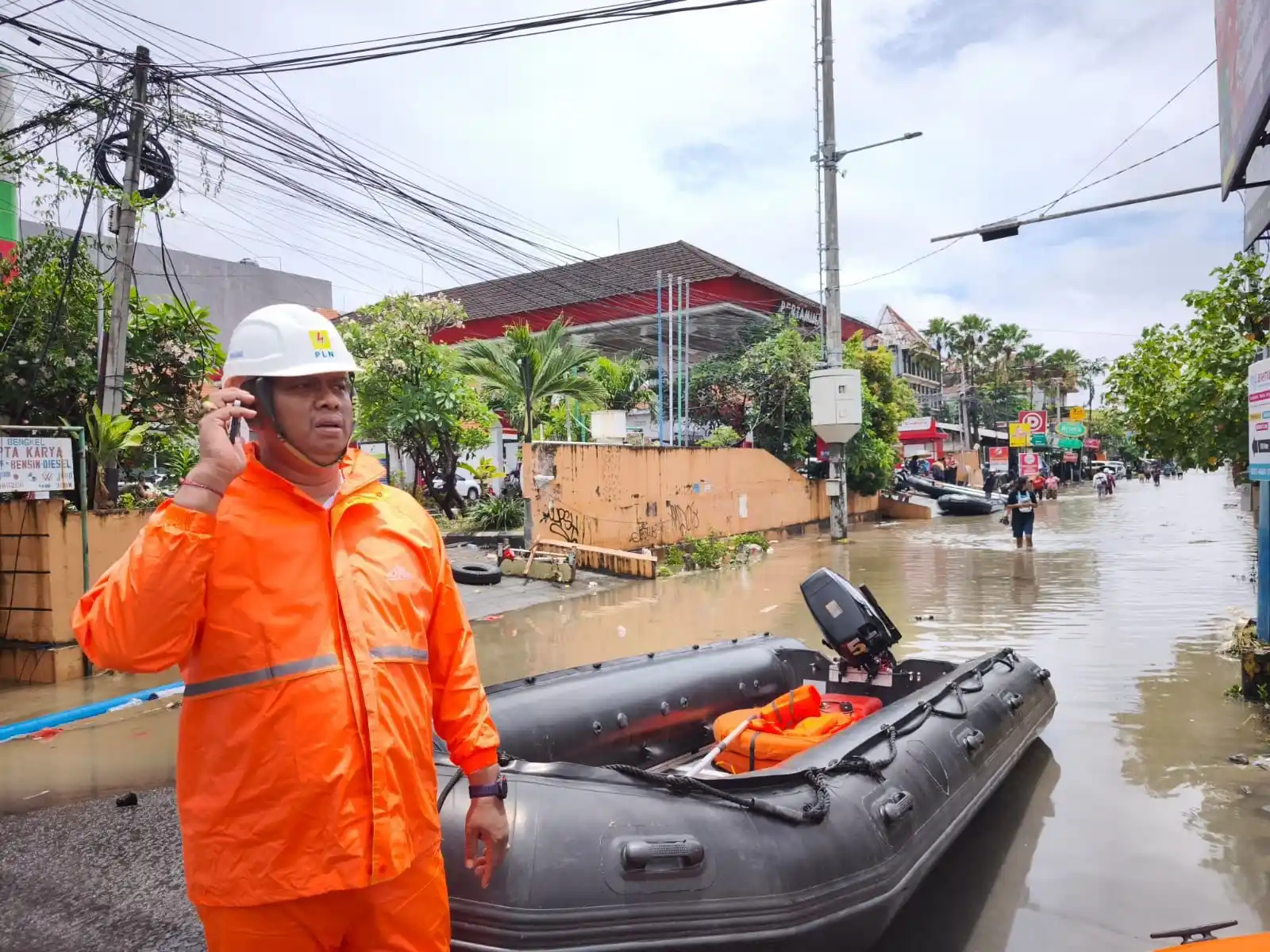 Petugas PLN sedang melakukan koordinasi pengamanan jaringan listrik di tempat terdampak banjir. Foto: PLN/MI