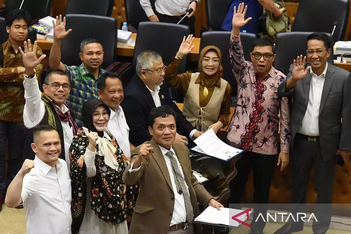 Menteri Hukum dan HAM Supratman Andi Agtas (kanan) dan Menteri Dalam Negeri Tito Karnavian (keempat kanan), bersama Wakil Ketua Badan Legislasi DPR yang juga pimpinan rapat Achmad Baidowi (kedua kanan), dan perwakilan fraksi yang menyetujui RUU melambaikan tangan usai menandatangani naksah persetujuan RUU Pilkada dalam rapat pengambilan keputusan pembahasan RUU Pilkada antara Baleg DPR dengan Pemerintah di Kompleks Parlemen, Senayan, Jakarta, Rabu (21/8/2024). Badan Legislasi DPR mengesahkan Revisi Undang - Undang (RUU) Pilkada dibawa ke rapat Paripurna untuk disahkan menjadi UU, dimana sebanyak delapan Fraksi DPR menyetujui RUU Pilkada dan hanya Fraksi PDI Perjuangan yang tak sependapat RUU tersebut dibawa ke Rapat Paripurna