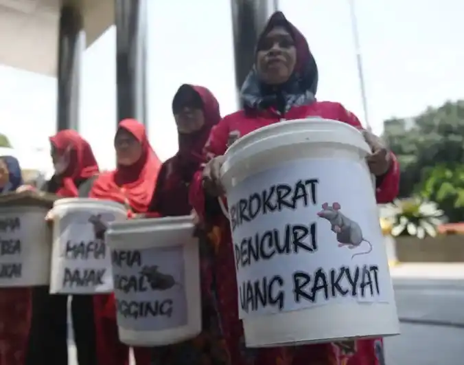 RUU Perampasan Aset yang sudah dibahas sejak 2006 itu dipercaya bisa merampas “aset yang tidak seimbang dengan penghasilan atau sumber penambahan kekayaan yang tidak dapat dibuktikan - Emak-emak memegang ember bertuliskan "Birokrat Pencuri Uang Rakyat" (Foto: Dok MI)