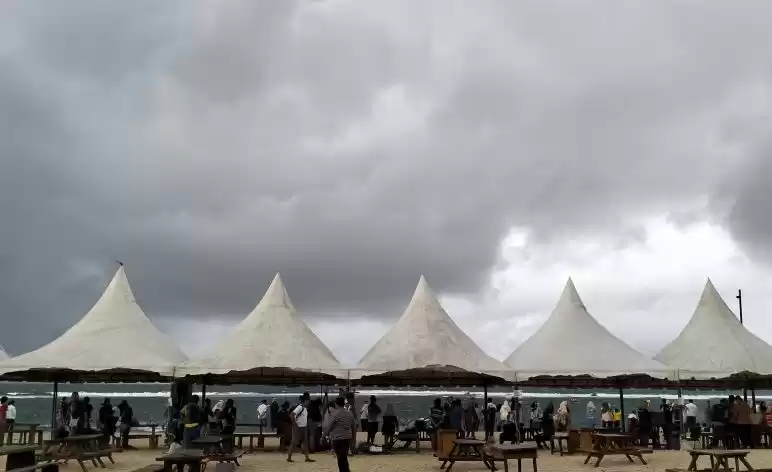 Sejumlah penonton dan ofisial berada di bibir Pantai Pulau Kapuk hendak Menyaksikan Final dayung. (Foto: Antara)