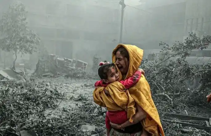 Seorang perempuan sambil menggendong anak bereaksi setelah serangan udara Israel.(Foto: Antara)