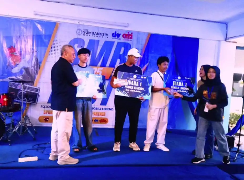 Kepala SMK Multimedia Sumbangsih Jakarta , Akhmad Nidom (kiri) saat menyerahkan hadiah kepada para pemenang kejuaran lomba mobile legends, SMB Festifal 2O25, Minggu, (15 /6/2025) di bangsal sekolah. (Foto: Dok MI/Gatot Eko Cahyono)
