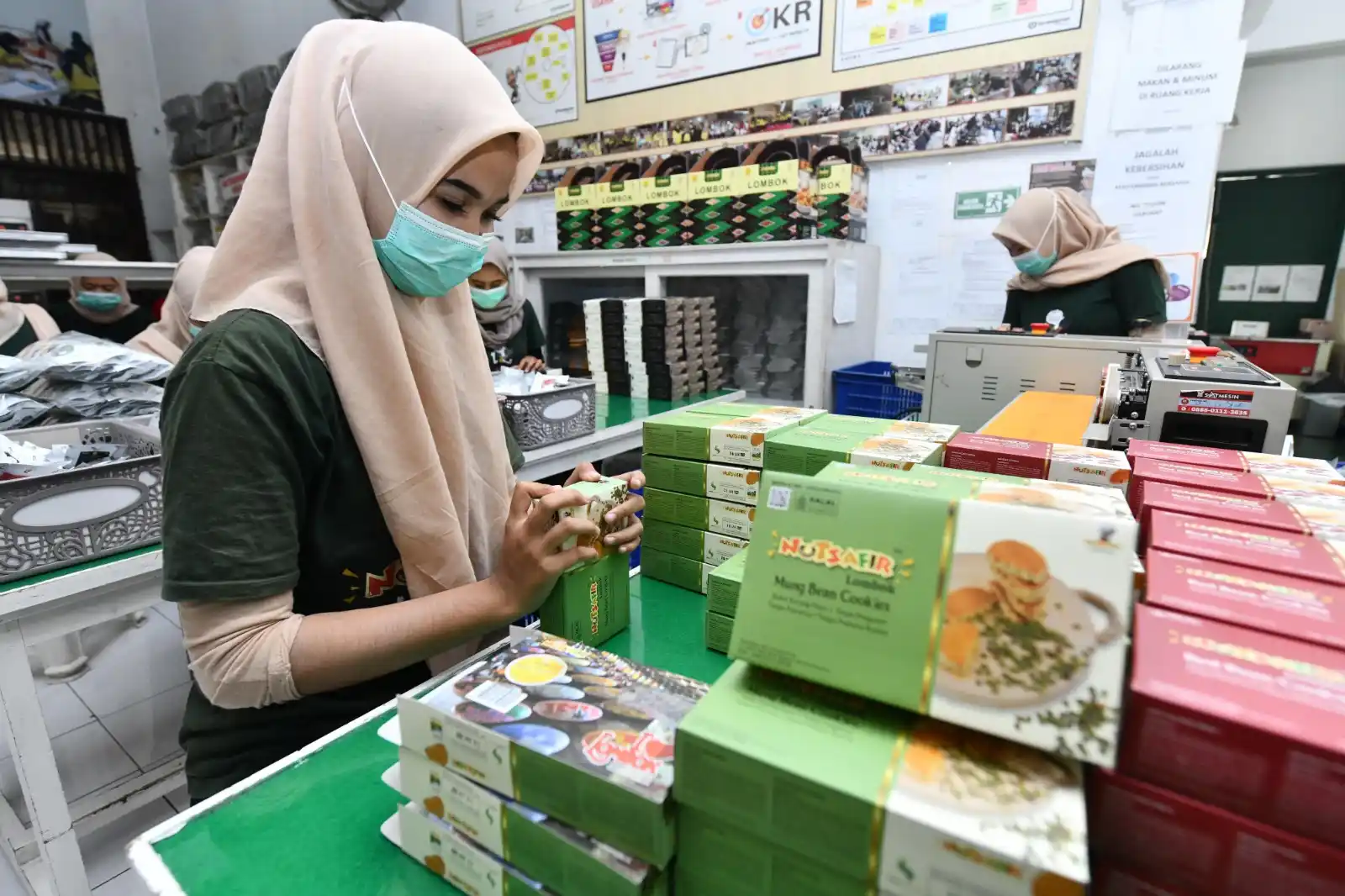 Karyawati Nutsafir sedang menyiapkan kemasan-kemasan Nutsafir untuk Booth UMKM Pertamina di Pertamina Grand Prix of Indonesia. Nutsafir menjadi salah satu pilihan kue kering favorit pelanggan, di ajang balap internasional ini. [Foto: Doc. Pertamina]