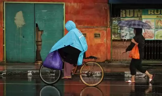 Warga menerobos hujan (Foto: Ist)