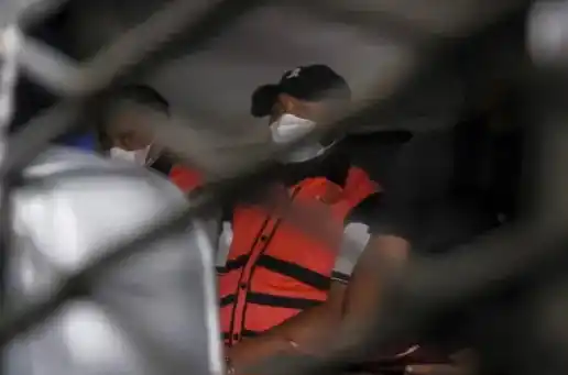 Dua tersangka dalam mobil tahanan usai menjalani pemeriksaan di Gedung Kejaksaan Agung, Jakarta, pada 14 April 2025